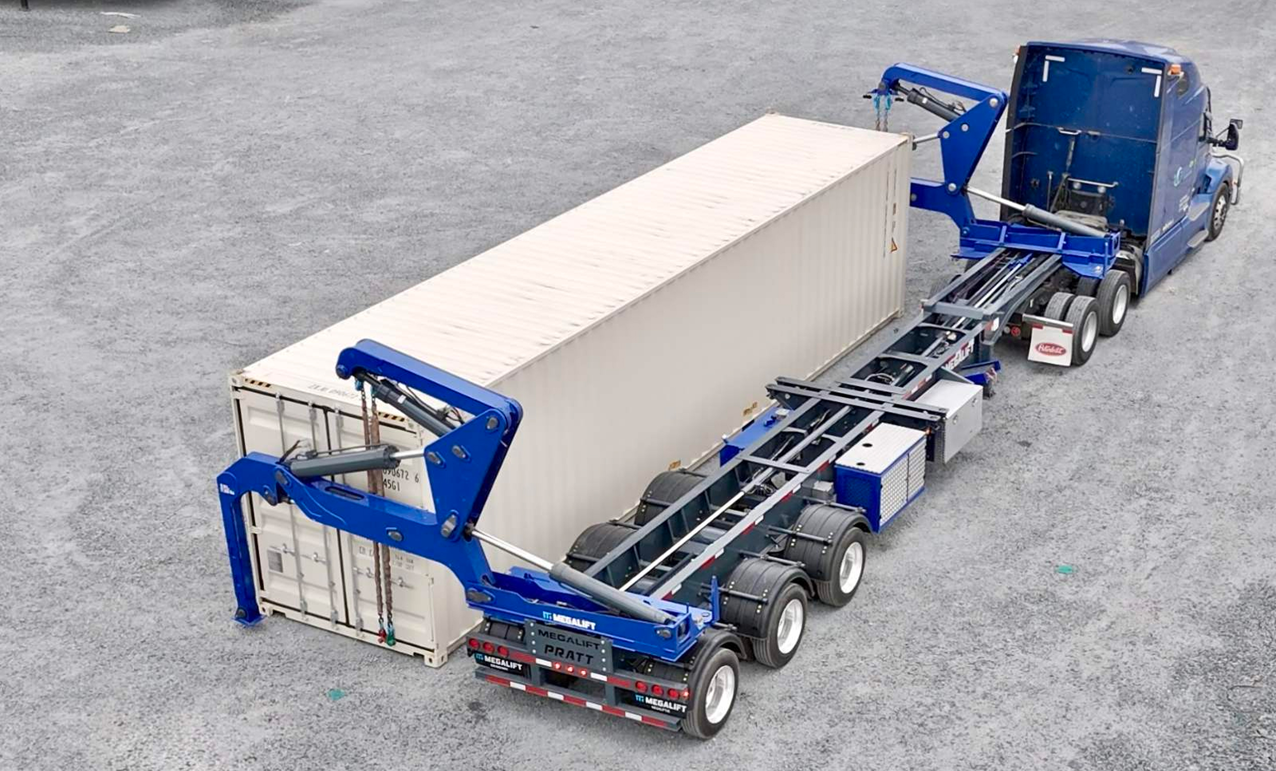 Blue side-loader truck lifting a large shipping container in an industrial area.